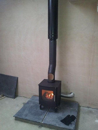 Wood burning stove with attached external air vent tube to outside