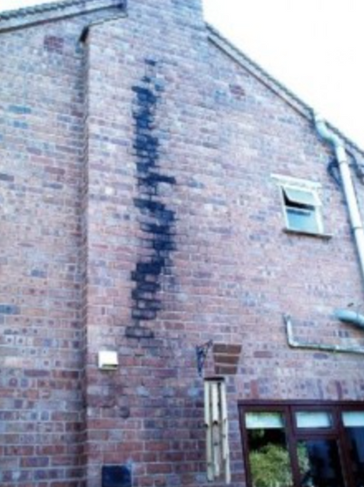 Outside chimney wall showing leakage of tar to outside from open fire inside