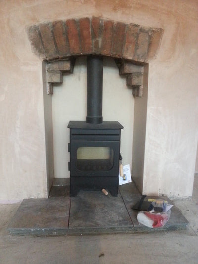 brick gather and arch above wood burning stove