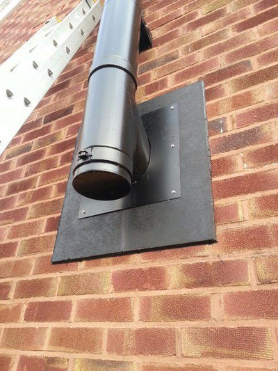 Twin wall flue exiting wall to outside. Wall is brick and finish plate made of Hardiebacker