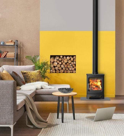 Saltfire Stoves Saltfire Peanut 3 Wood Burning Stove 3kW Small Cast Iron next to a built in wall logstore